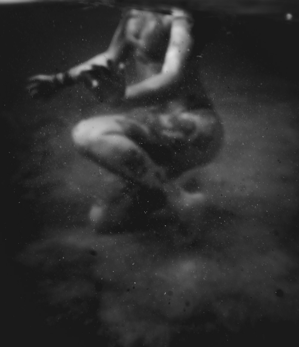 a black and white photo of a woman under water