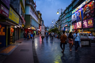 a group of people walking down a street next to tall buildings