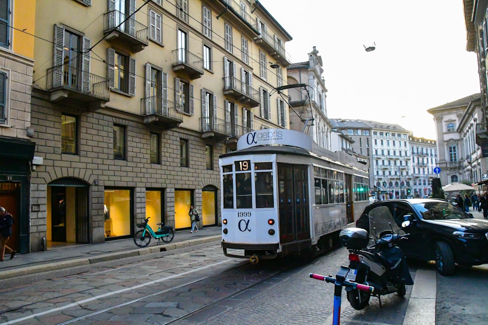 a trolley car on a city street next to a motorcycle