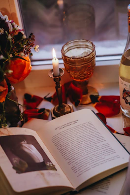 A serene scene of a perfume bottle beside an open book and a cup of tea.