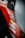 A close-up view of a red vehicle panel adorned with multiple brand stickers, including AEM and Trail Rated 4x4. The focus is on the stickers with some parts of the vehicle's interior visible.