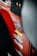 A close-up view of a red vehicle panel adorned with multiple brand stickers, including AEM and Trail Rated 4x4. The focus is on the stickers with some parts of the vehicle's interior visible.