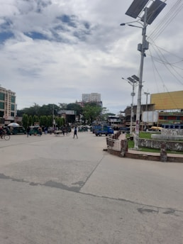 A vibrant city street with electric vehicles and solar panels on buildings, illustrating sustainable urban mobility.