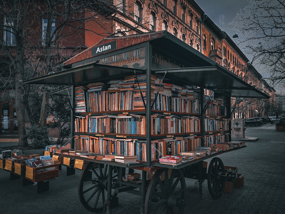 a cart filled with lots of books in front of a building