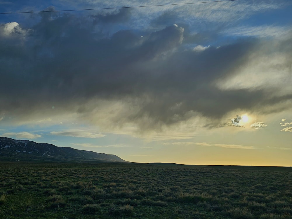 a large open field with a mountain in the background