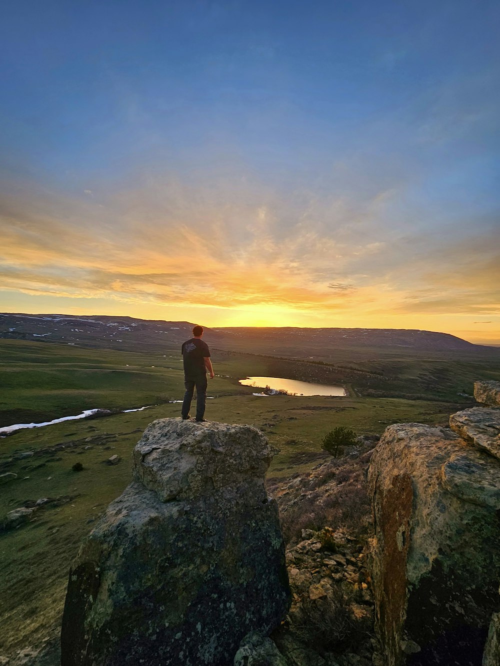 a person standing on top of a large rock