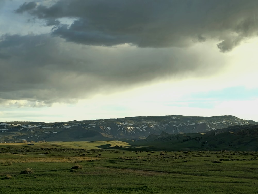 a green field with mountains in the background