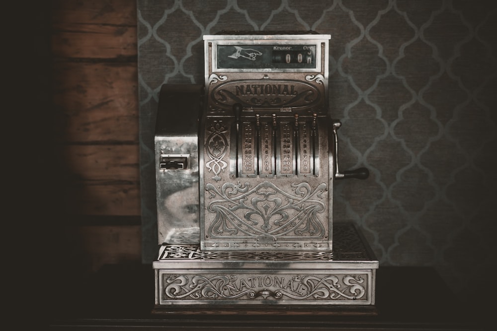 a silver machine sitting on top of a wooden table