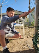 A person painting a wooden project in their backyard.