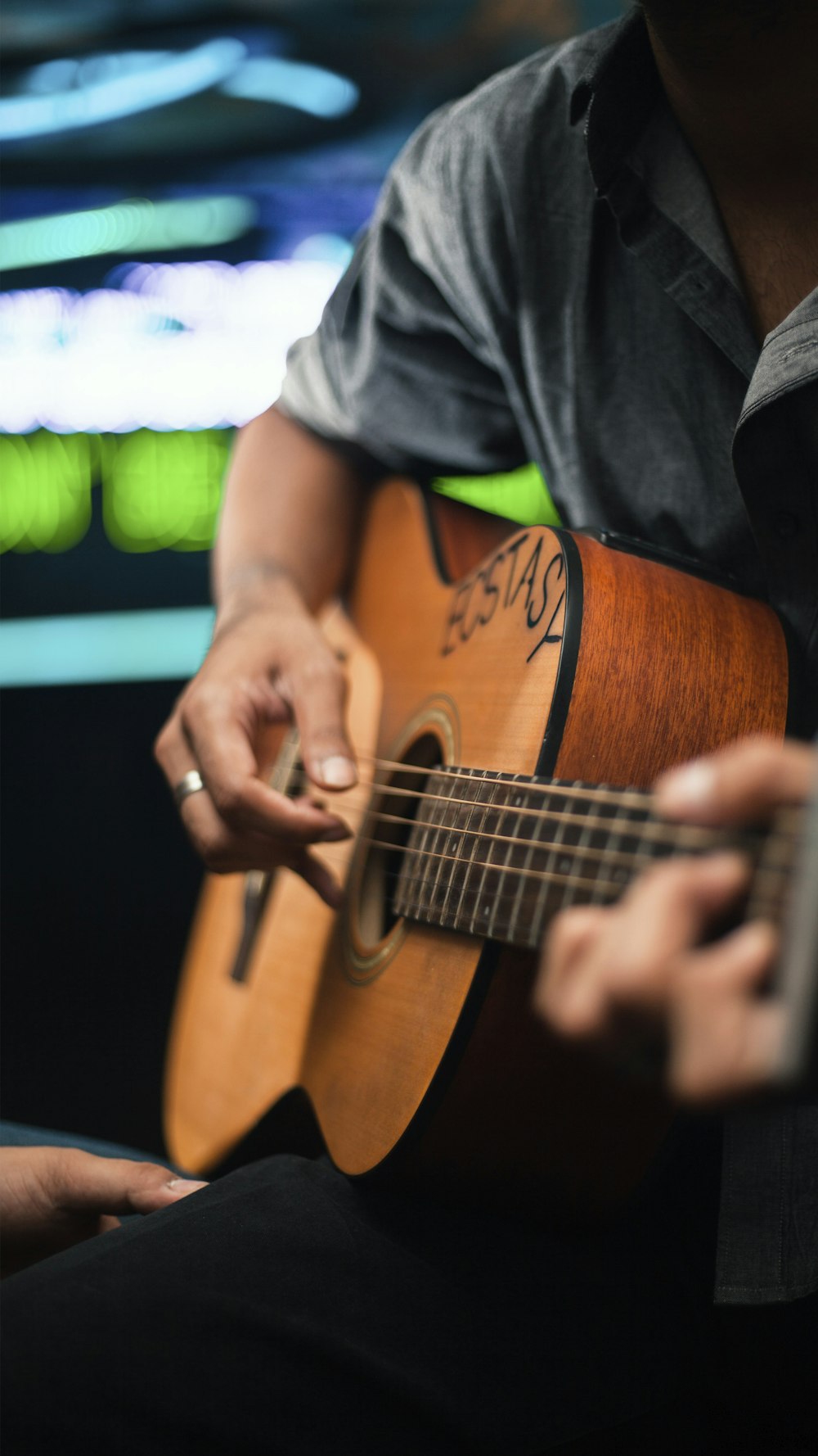 a man sitting down playing a guitar