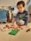 A joyful child building a colorful tower with mini bricks on a sunny playroom floor.