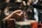 Hands are shown preparing a coffee machine for use, with a portafilter being inserted into an espresso machine. The background has a blurred appearance, focusing on the action of making coffee.