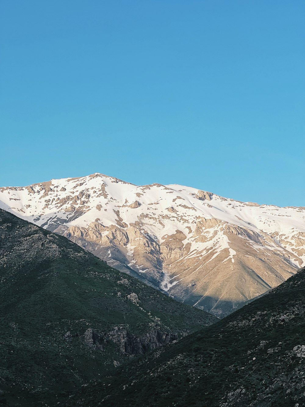 a view of a mountain range with snow on the top
