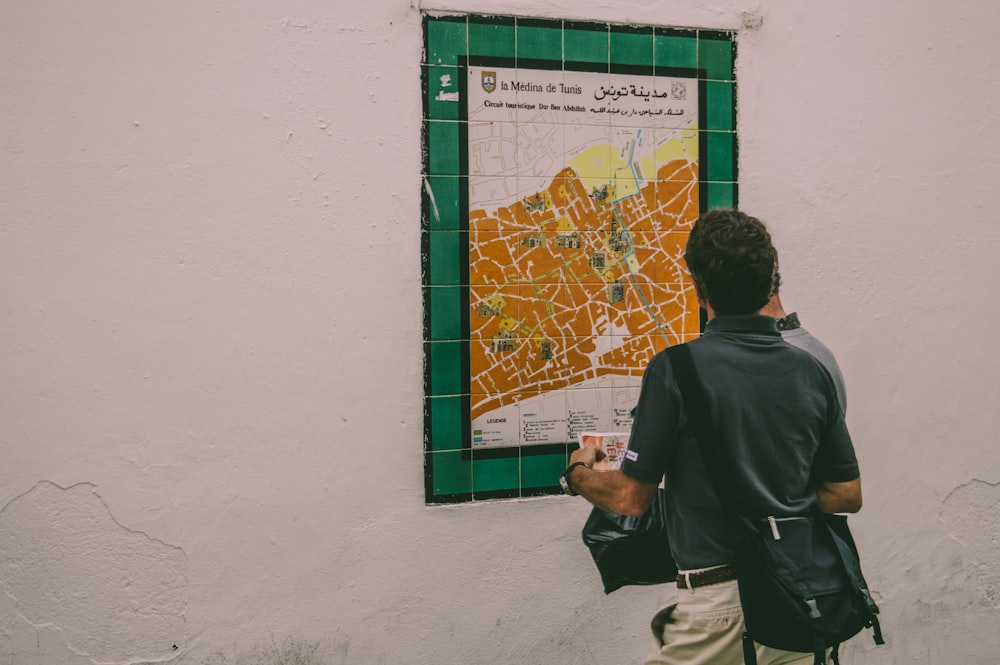 a man looking at a map on a wall