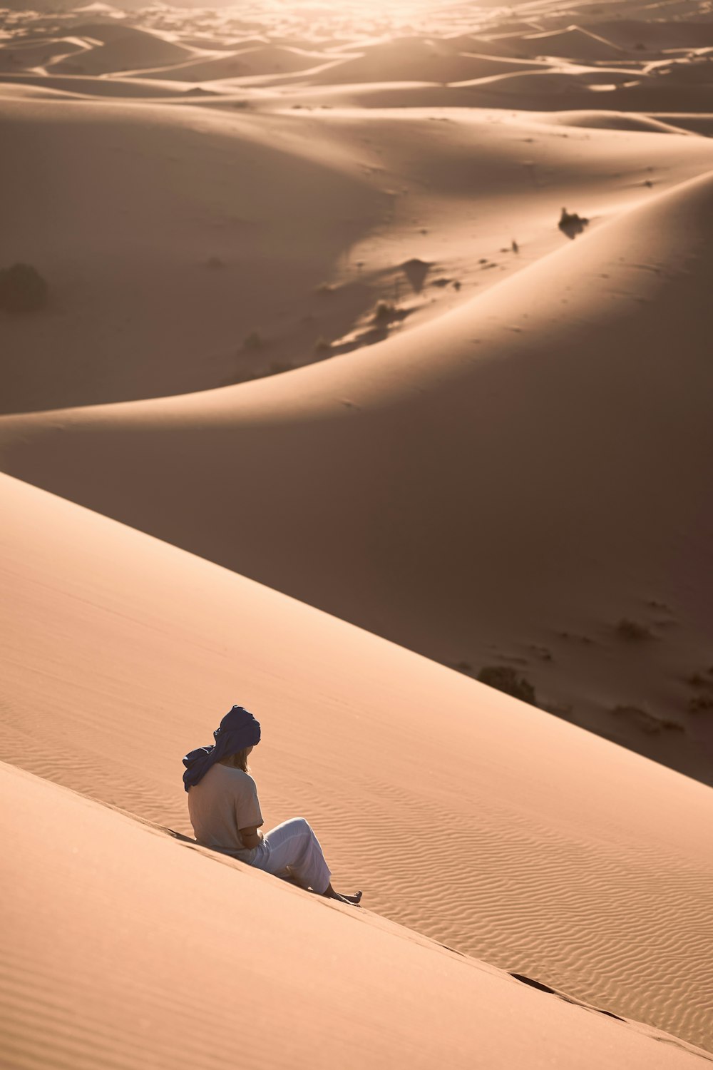 uma pessoa sentada no meio de um deserto