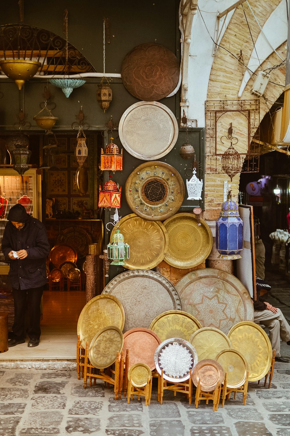 a man standing in front of a store filled with lots of plates