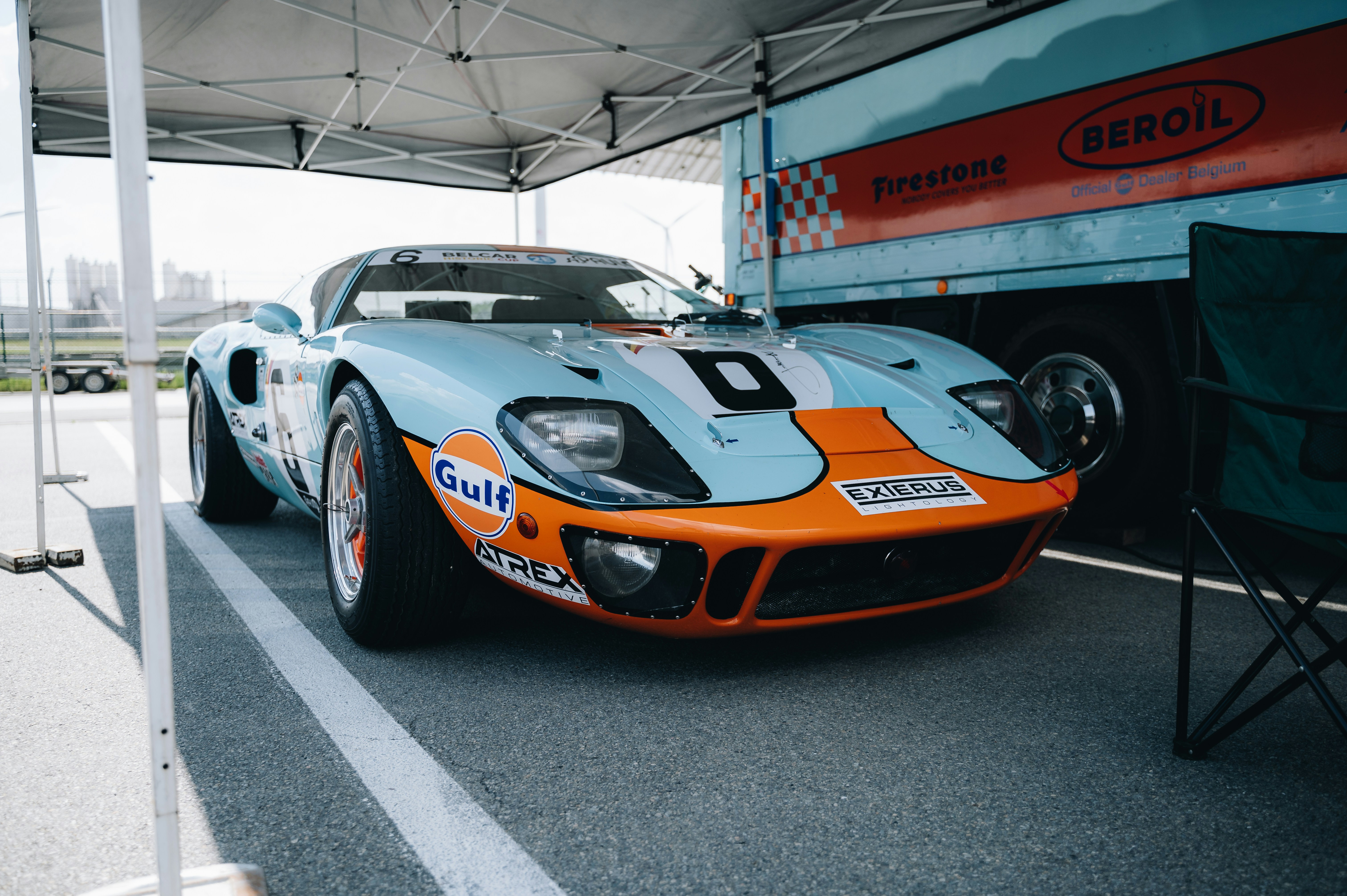an orange and blue race car parked in a parking lot