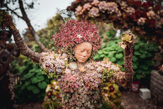 Close-up of an axolotl-inspired sculpture surrounded by vibrant native plants.