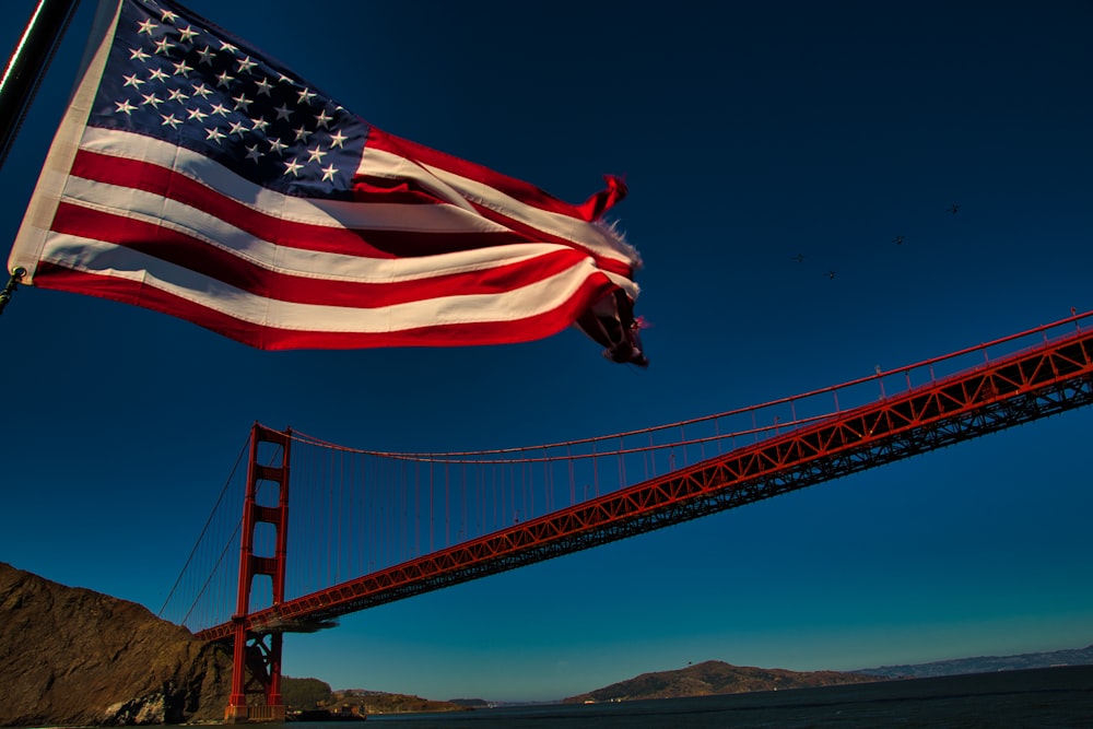 a large american flag flying over the golden gate bridge