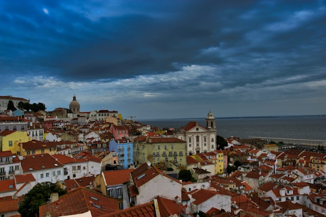 A serene coastal view of Qingdao’s iconic red-roofed buildings against a bright blue sky.