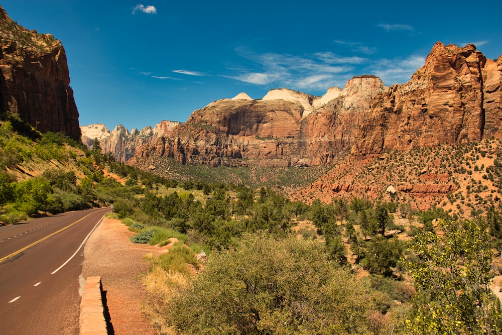 a scenic view of a mountain range with a road in the foreground