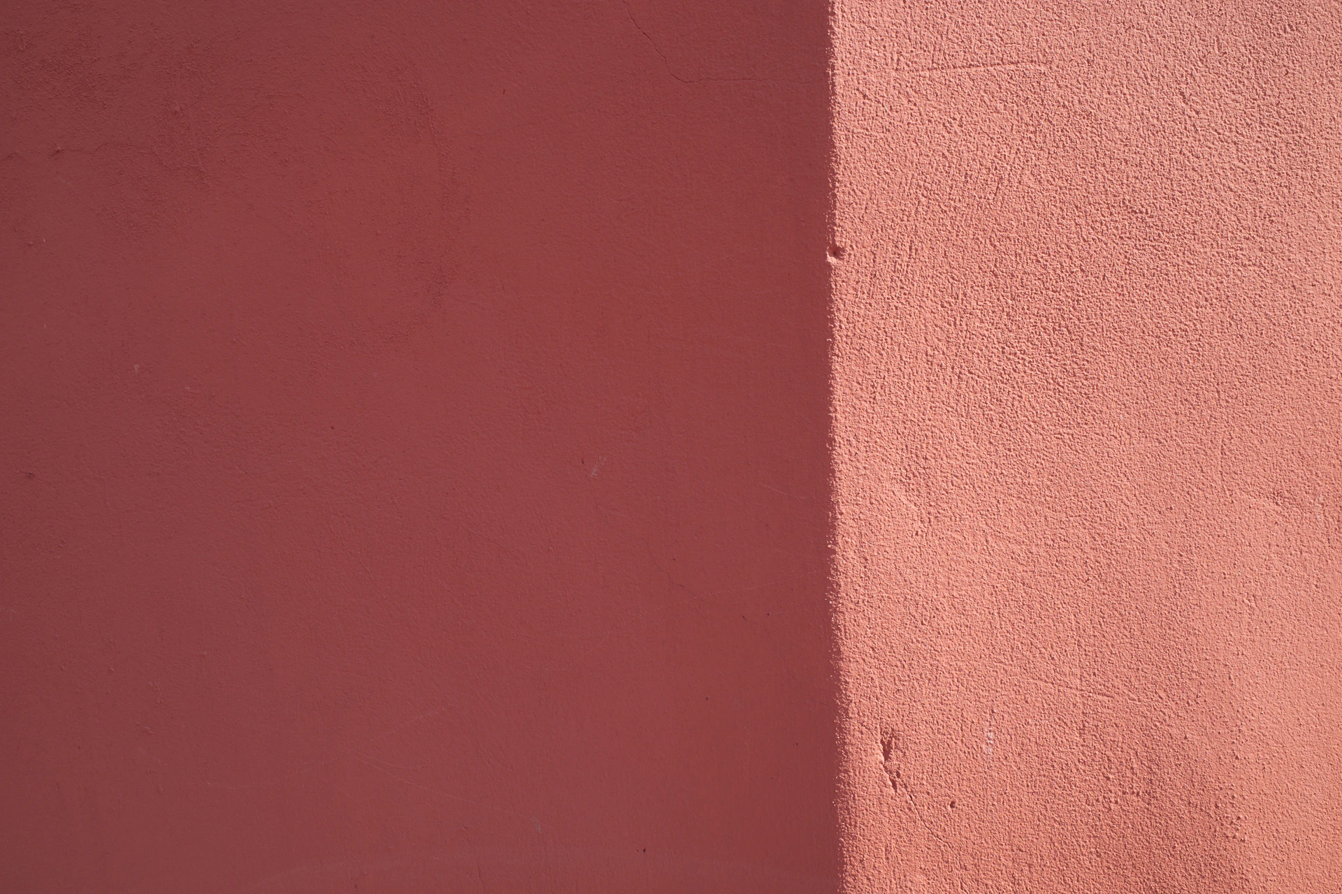a close up of a pink wall with a clock on it