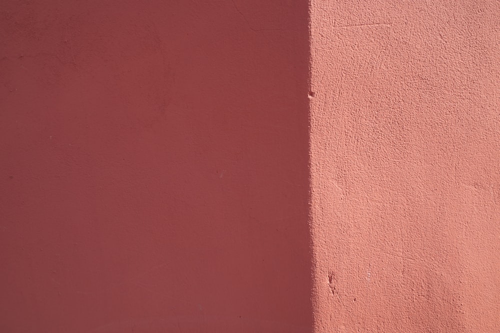 a close up of a pink wall with a clock on it