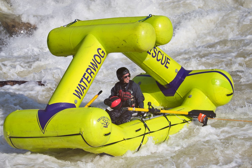 a man riding on the back of a raft down a river