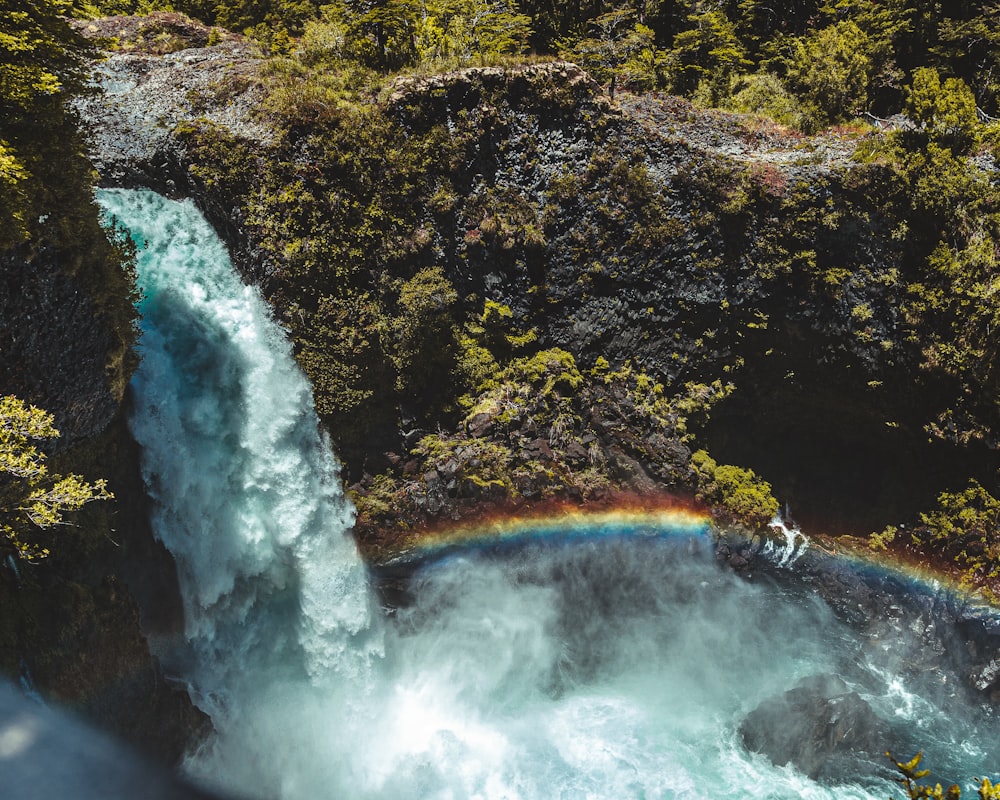 a waterfall with a rainbow in the middle of it