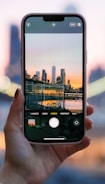 A close-up of a hand holding a SIM card against a backdrop of a city skyline at dusk