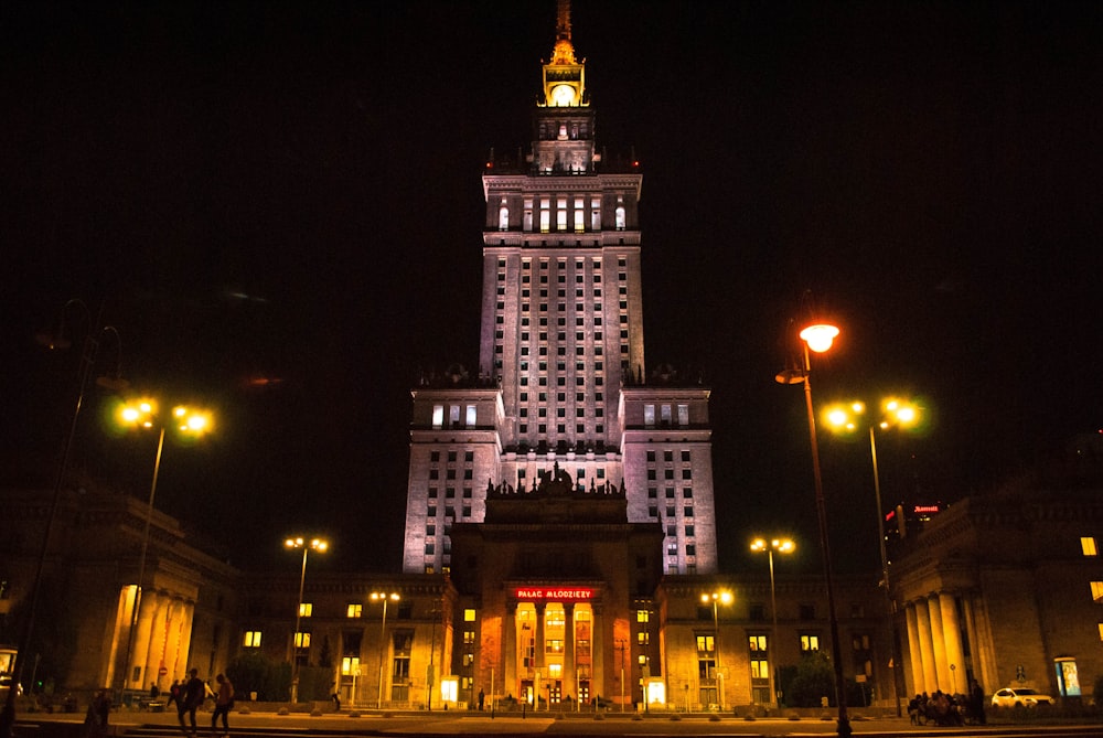 a tall building with a clock tower lit up at night