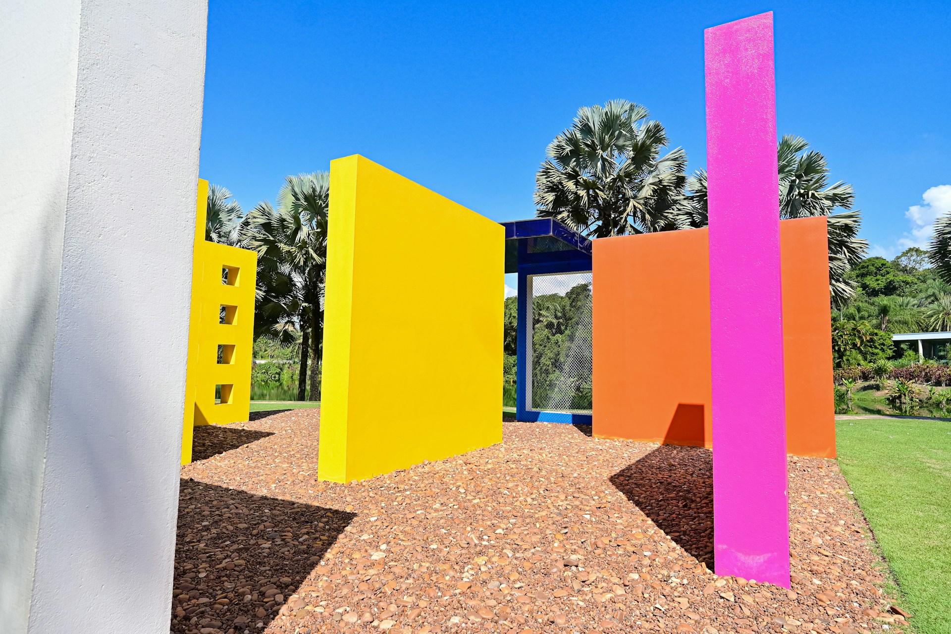 The surreal garden of Xilitla with colorful sculptures and dense tropical vegetation under a bright sky.