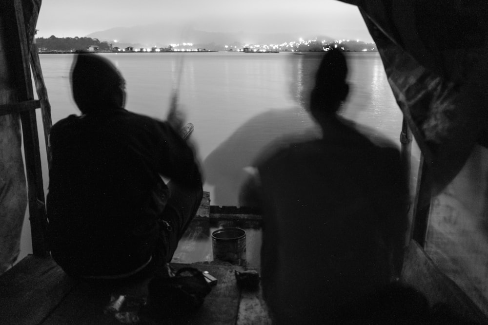um par de pessoas sentadas em cima de um barco