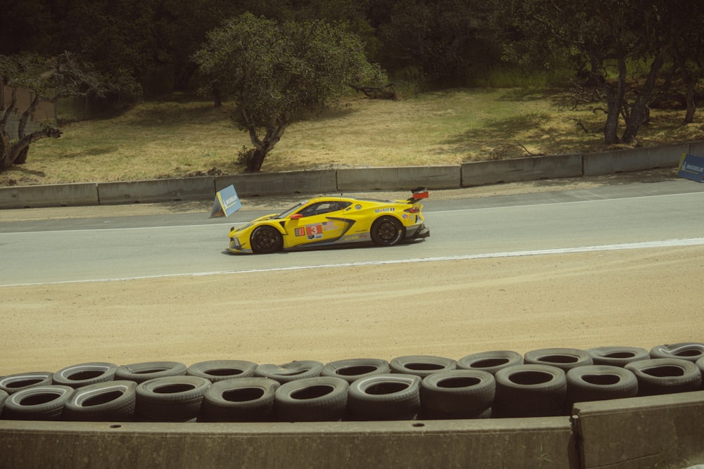 a yellow sports car driving down a race track