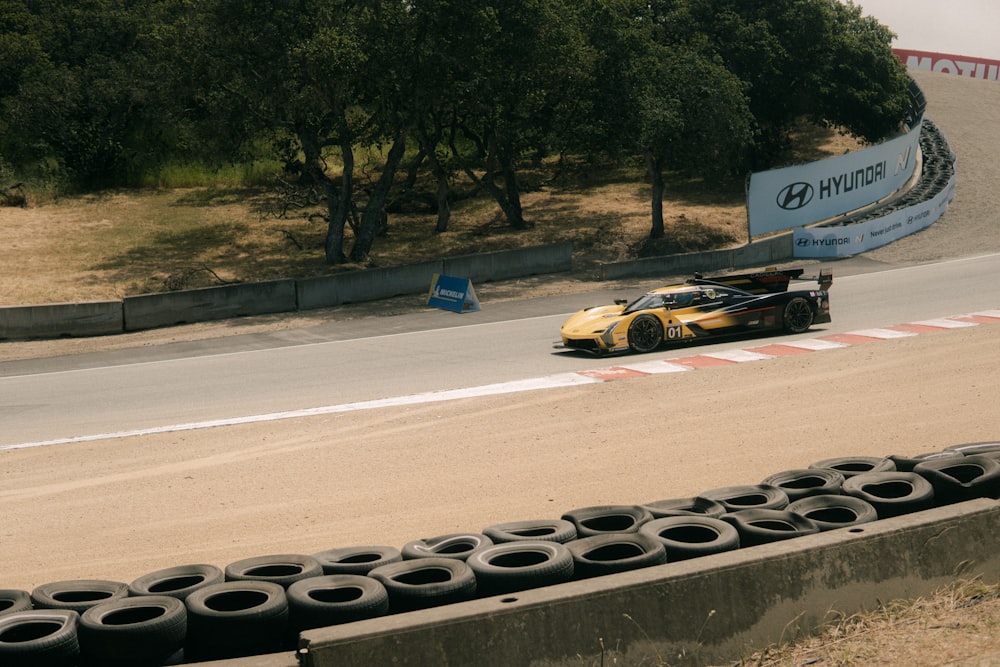 a yellow race car driving down a race track