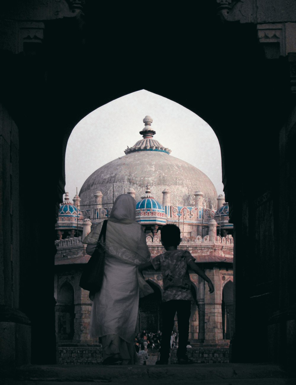 a group of people walking through an archway