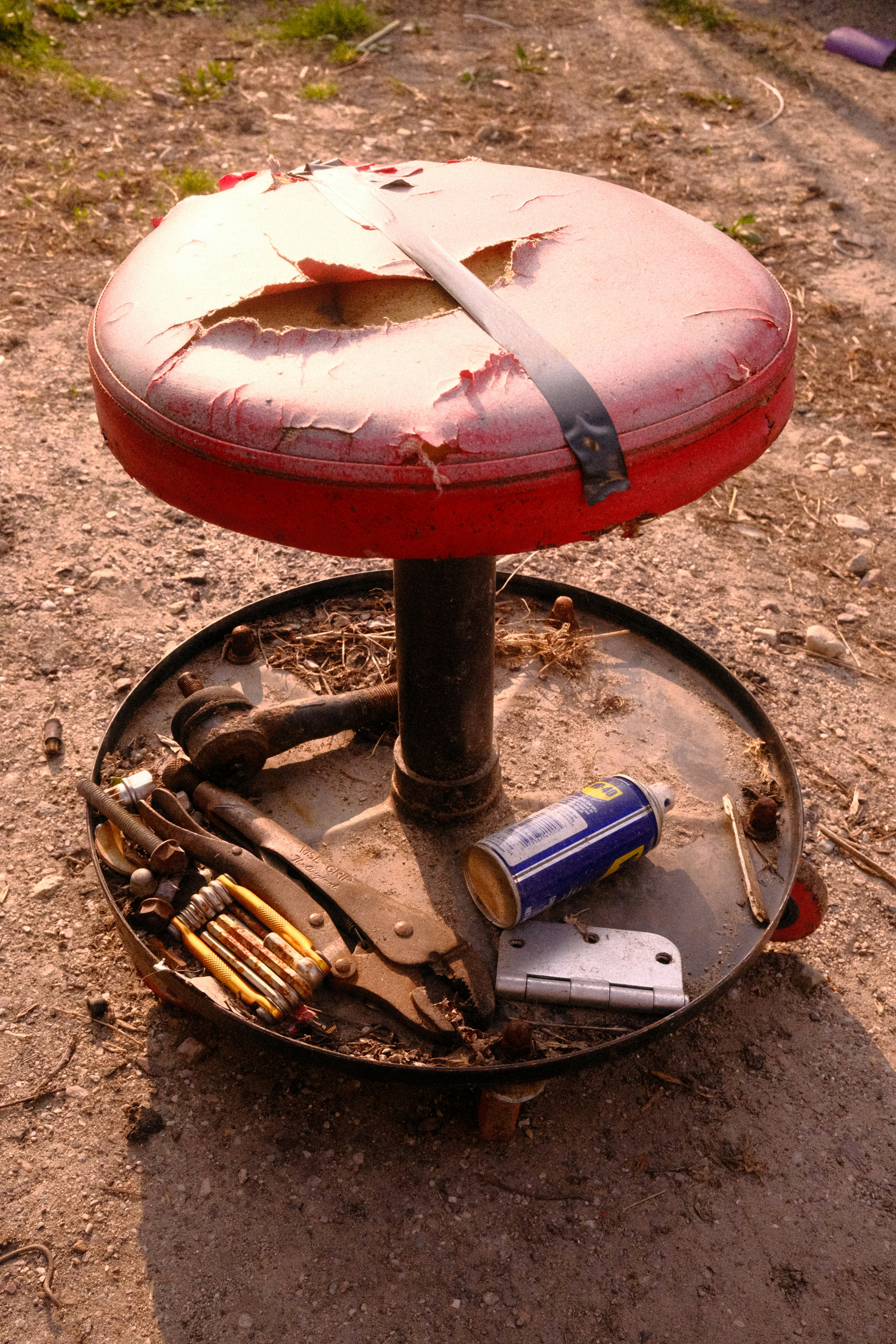 a red stool sitting on top of a metal plate