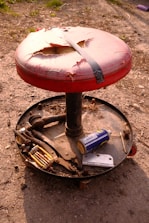 A finished wooden stool displayed on a workbench with tools around.