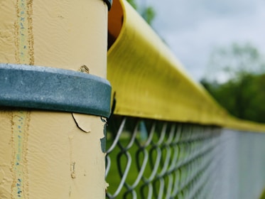 Hands installing a thick American-made fence clip on a metal post.