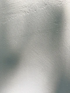 Close-up of a wall painted with smooth white rubberized paint under soft natural light