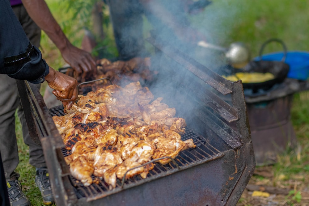 a man grilling chicken on a grill outside