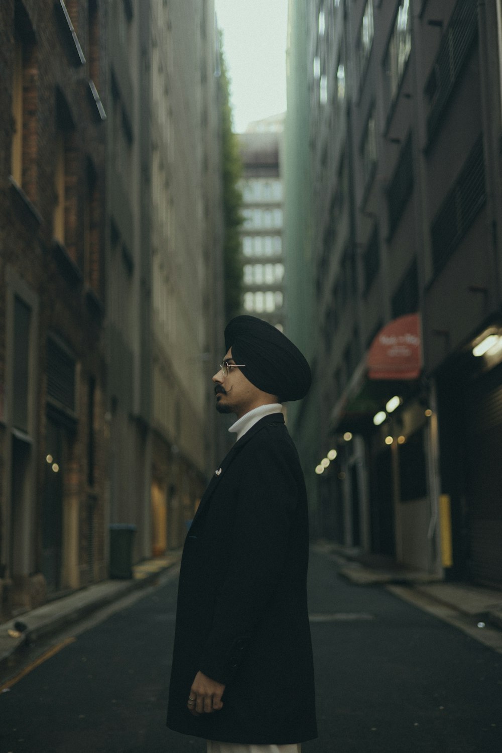 a man in a turban standing in an alleyway