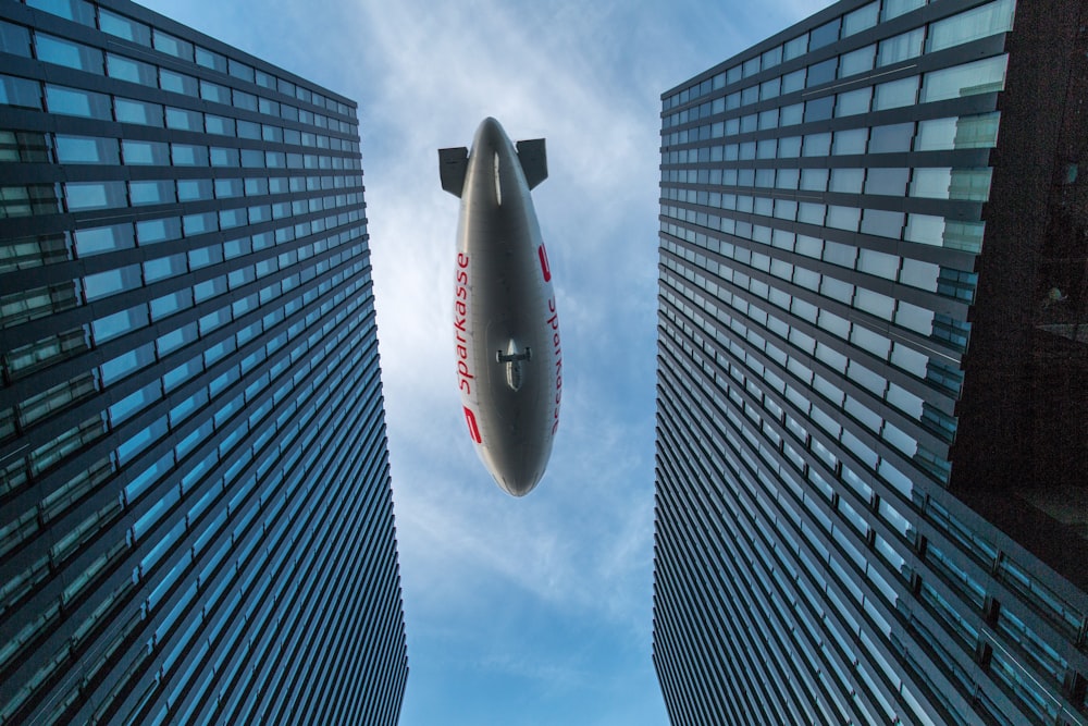 a large jetliner flying through the air near tall buildings