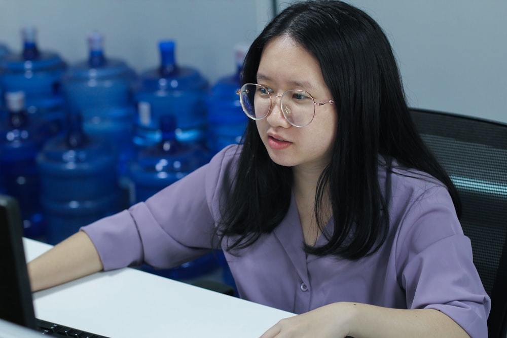 a woman sitting at a desk with a laptop