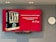 A large screen displays a book titled 'Team Lead Succeed' by Nick Fewings next to a motivational quote about teamwork attributed to the same author. The background is predominantly red. To the right of the screen, there is a white analog clock. Below the screen, a video conferencing camera is mounted.