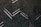 Aerial view of a series of solar panels embedded within dense green foliage, arranged in a geometric zigzag pattern.