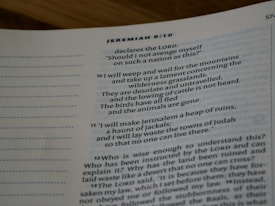 A close-up view of a page from a Bible, showing a passage from Jeremiah 9:10. The text is printed in black on white paper, with some sections highlighted in blue. The page number 574 is visible at the top right corner.