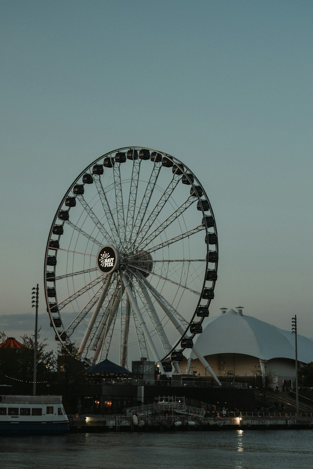 a large ferris wheel sitting next to a body of water