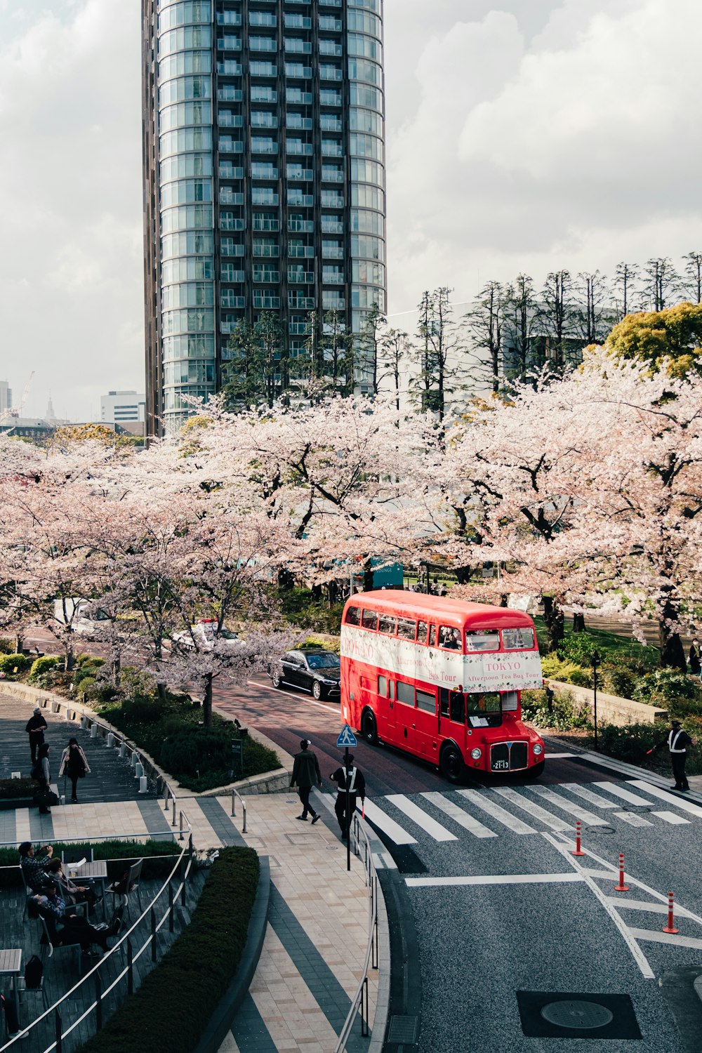 a red double decker bus driving down a street