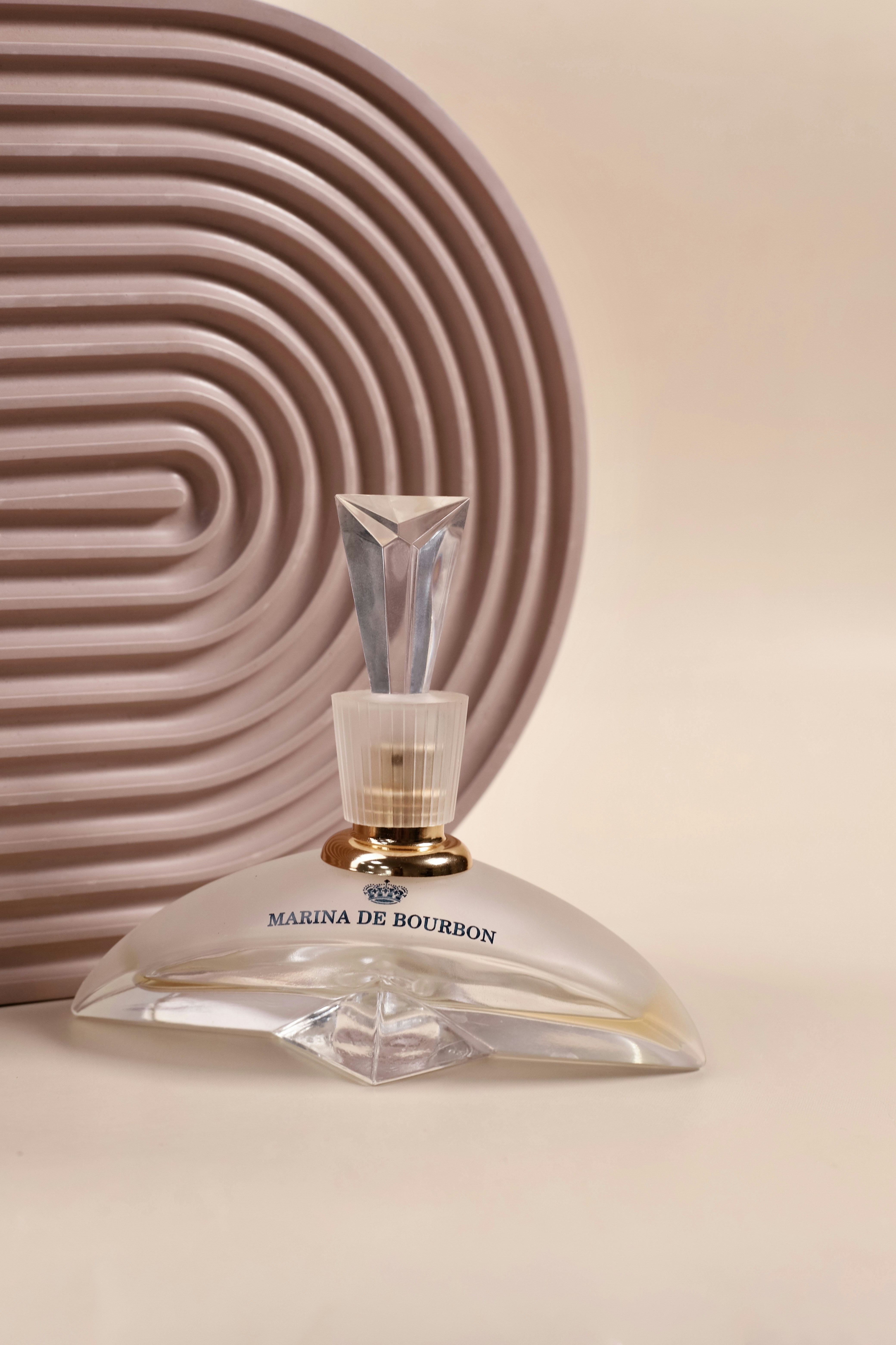 Elegant frosted perfume bottle with purple tones on a light grey background
